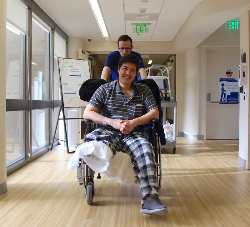 REVIEW PHOTO: SAM STITES - Palisades Market employee Mohammad Fawad Mohammadi smiled wide in April as he was wheeled out of Legacy Emanuel Medical Center, where he was treated after a brutal attack on the Oregon coast.