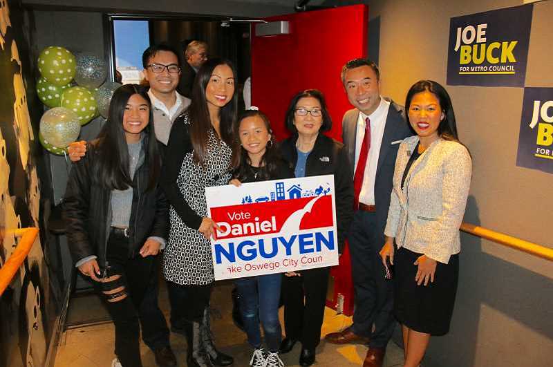 REVIEW PHOTO: J. BRIAN MONIHAN - Daniel Nguyen and his wife Katherine pause with Nguyen's mother and extended family at an election night party at the Lake Theater & Café. Nguyen garnered the most votes of any candidate to become the first person of color ever elected to the Lake Oswego City Council.