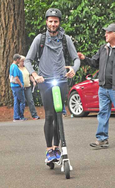 REVIEW PHOTO: VERN UYETAKE - Lake Oswego City Councilor Joe Buck goes for a spin on an electric scooter in August during an EV Fair sponsored by the Lake Oswego Sustainability Network and the City's Sustainability Advisory Board. 