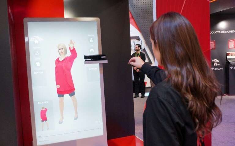 An employee of Chinese tech giant JD.com shows an augmented reality system that allows customers to virtually try on clothing at